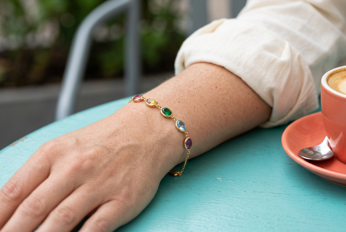 Colorful bracelet worn at the wrist with ivory sleeve and turquoise cafe table