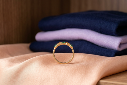 Emerald Dawn ring concept with peach fabric and folded navy and lavender clothing