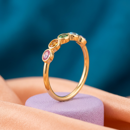 Rainbow Arc five-color oval ring with closed gold-tone band on lilac pedestal