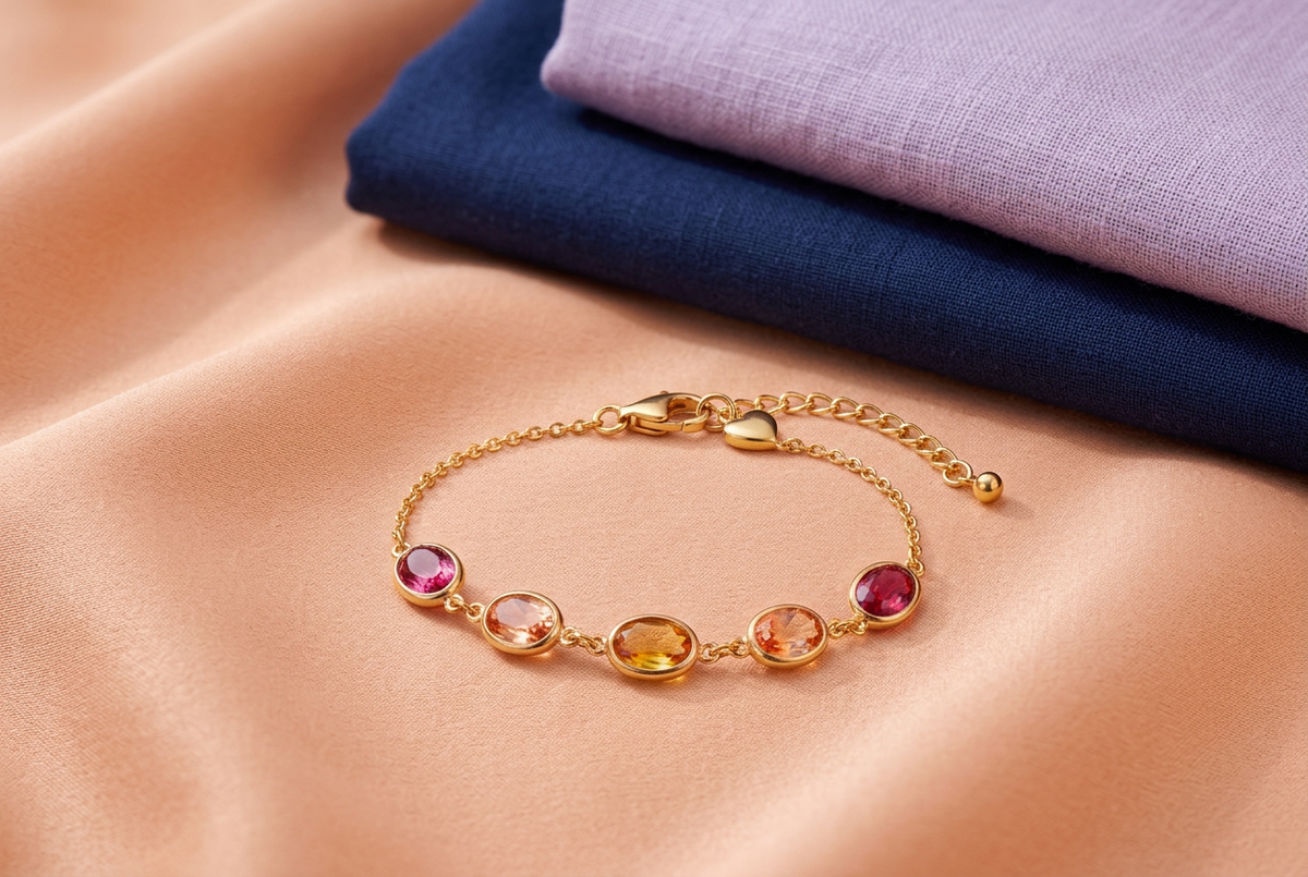 Complete warm-colored bracelet beside navy and lavender clothes on peach fabric