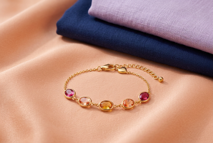 Complete warm-colored bracelet beside navy and lavender clothes on peach fabric