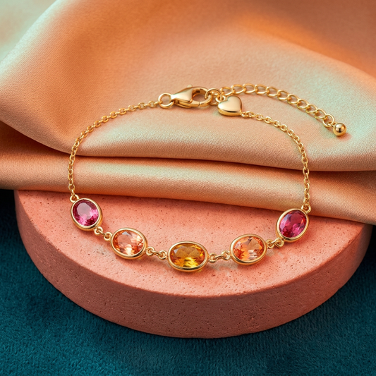 Sunset Bloom five-oval pink peach amber bracelet on apricot silk and coral pedestal