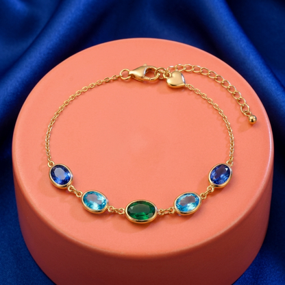 Complete Ocean Muse bracelet on coral pedestal against cobalt fabric