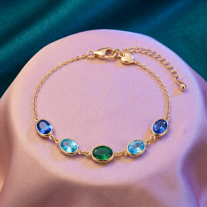 Ocean Muse blue aqua green oval bracelet with gold-tone chain on peach fabric