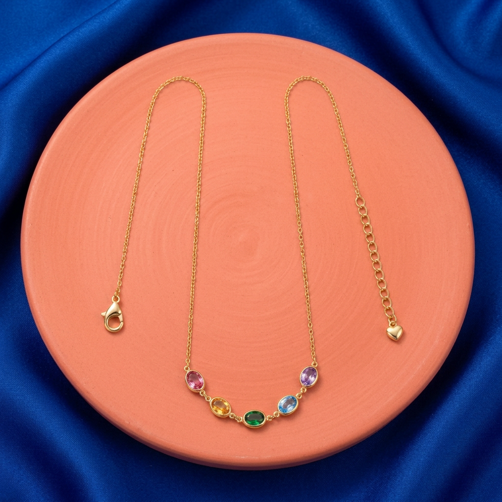Complete five-color necklace arranged on coral pedestal against cobalt fabric