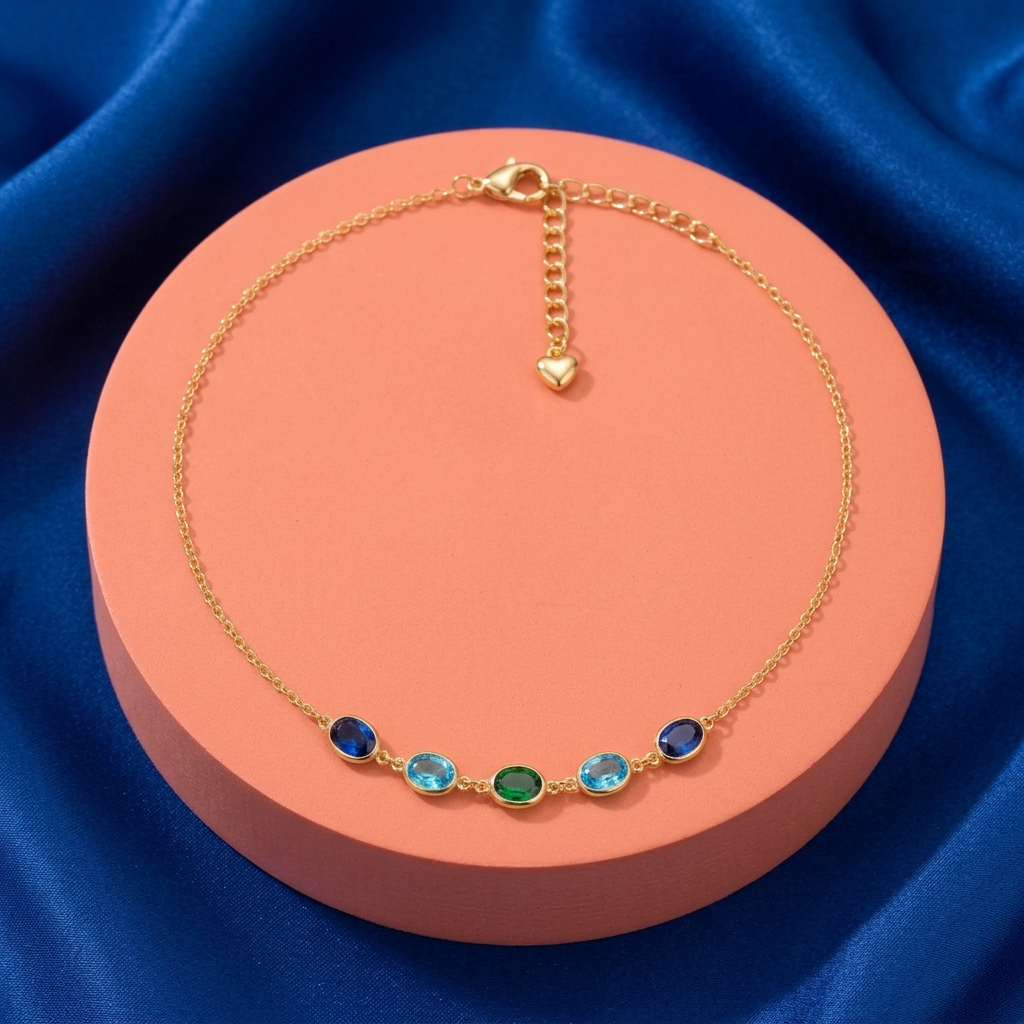 Complete blue green five-oval necklace on coral pedestal against cobalt fabric