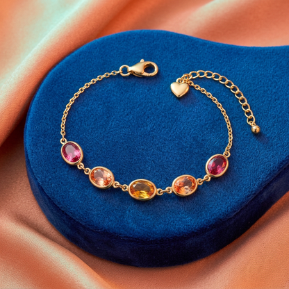 Warm-colored oval bracelet arranged on cobalt blue against peach fabric