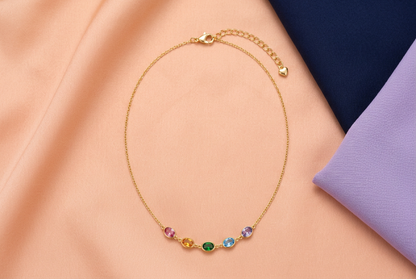 Complete Prism Garden necklace on peach fabric beside navy and lilac clothing